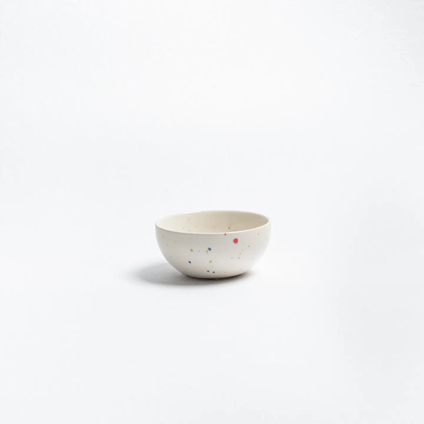 Small ceramic bowl with speckled pattern on a white background