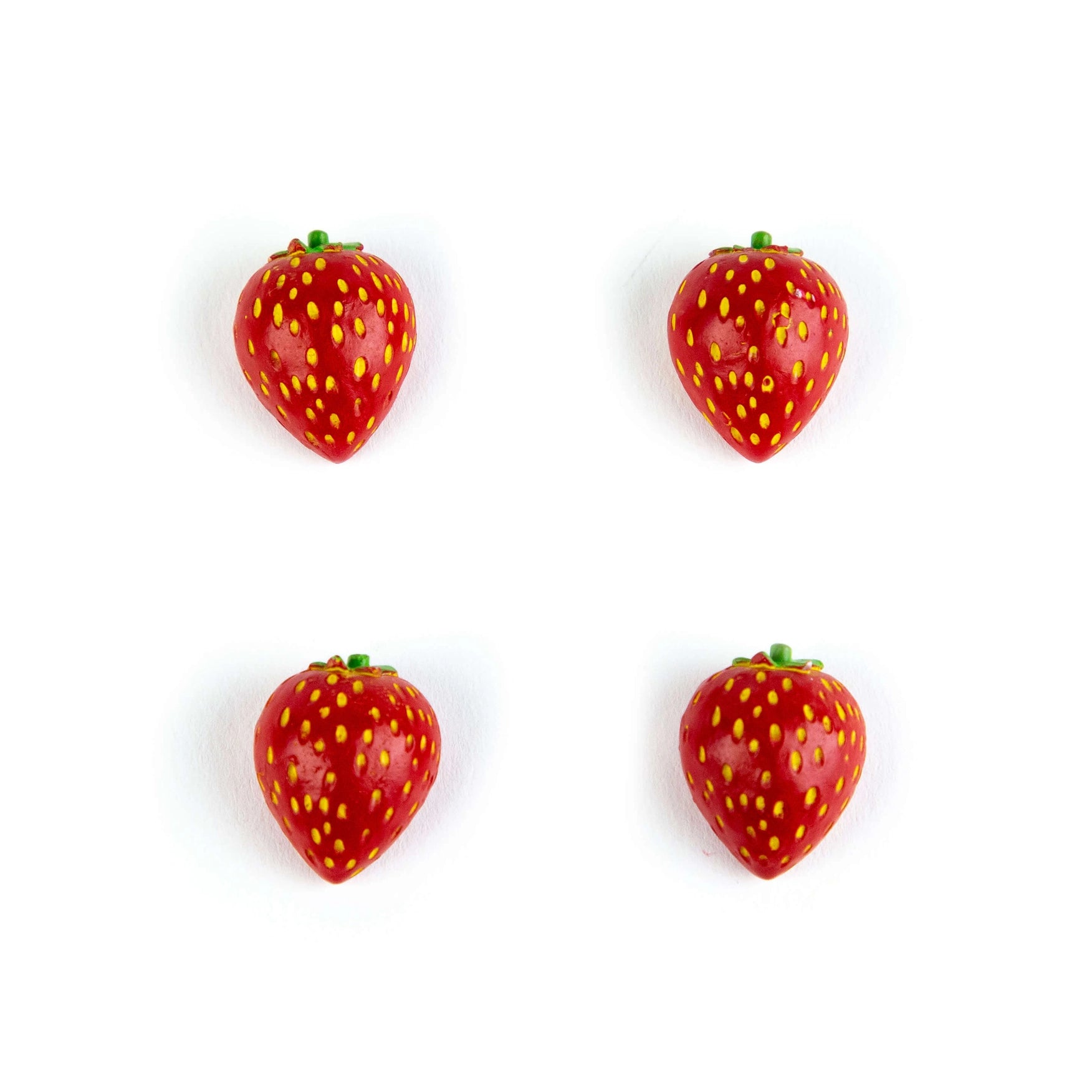 Four small strawberry-shaped items arranged in a 2x2 grid on a plain white background.