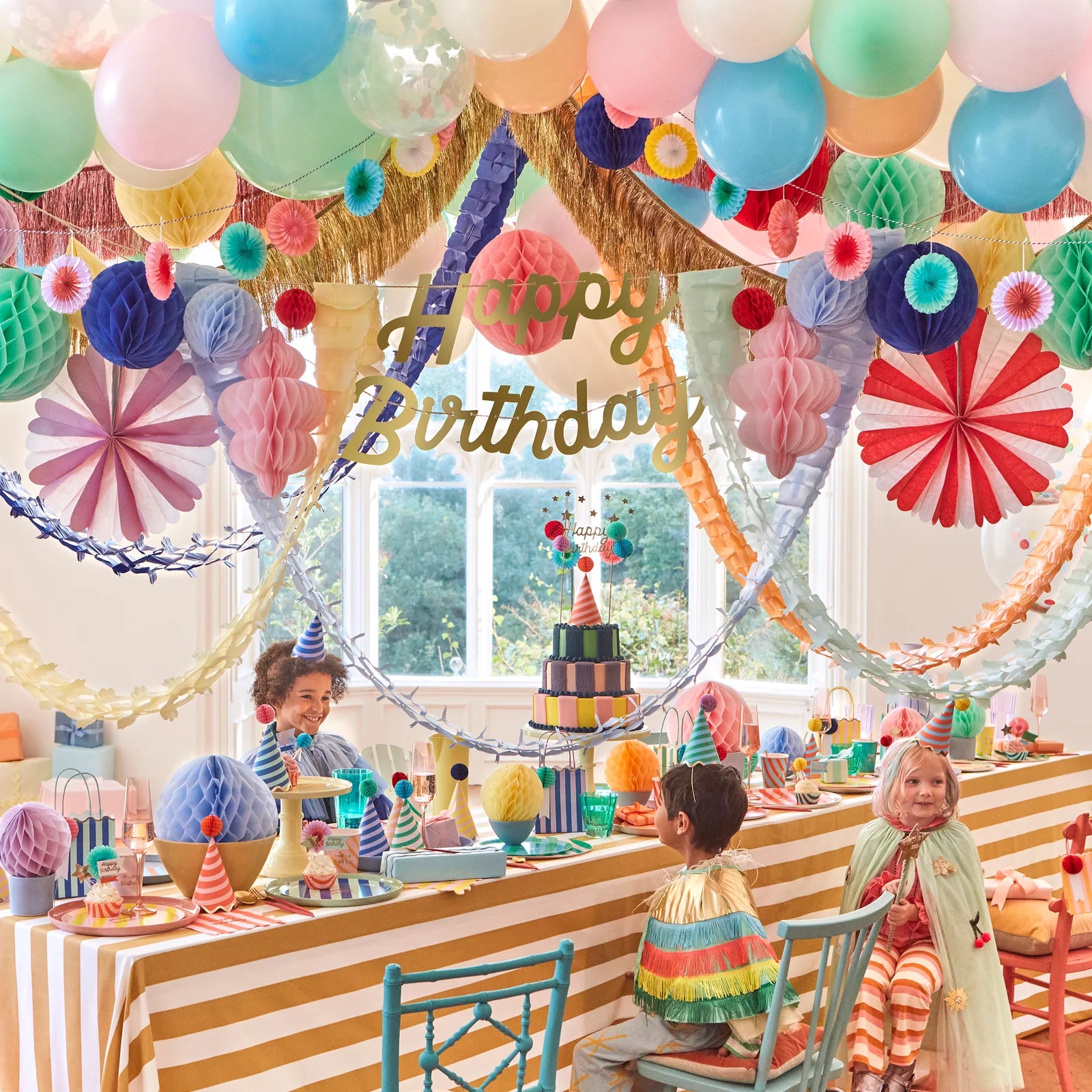 Children at a birthday party with colorful decorations and balloons.