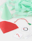 A paper cone with tattoos, a charm and fortune with some unraveled crepe paper in the background