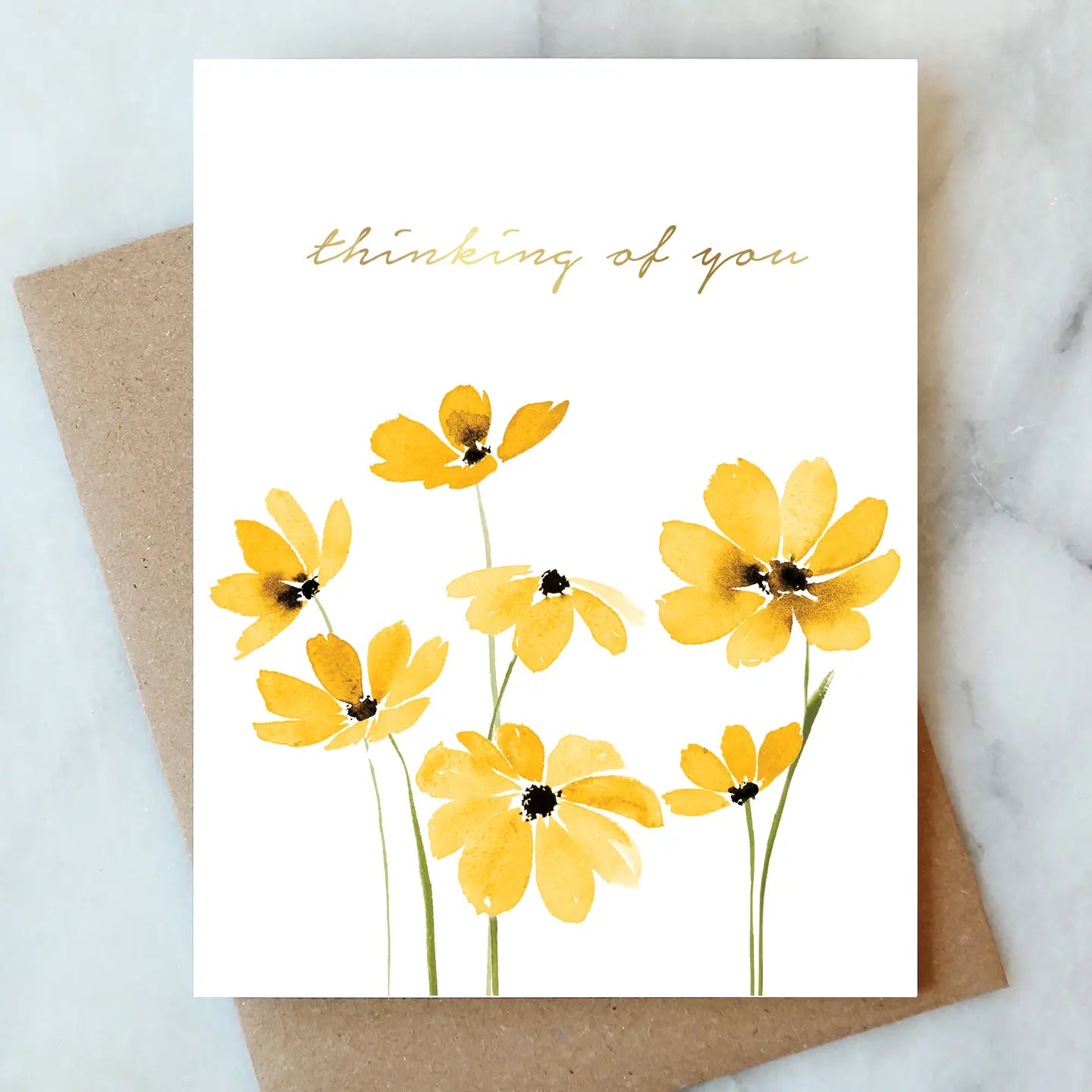 Greeting card with yellow flowers and 'thinking of you' text on a marble surface.