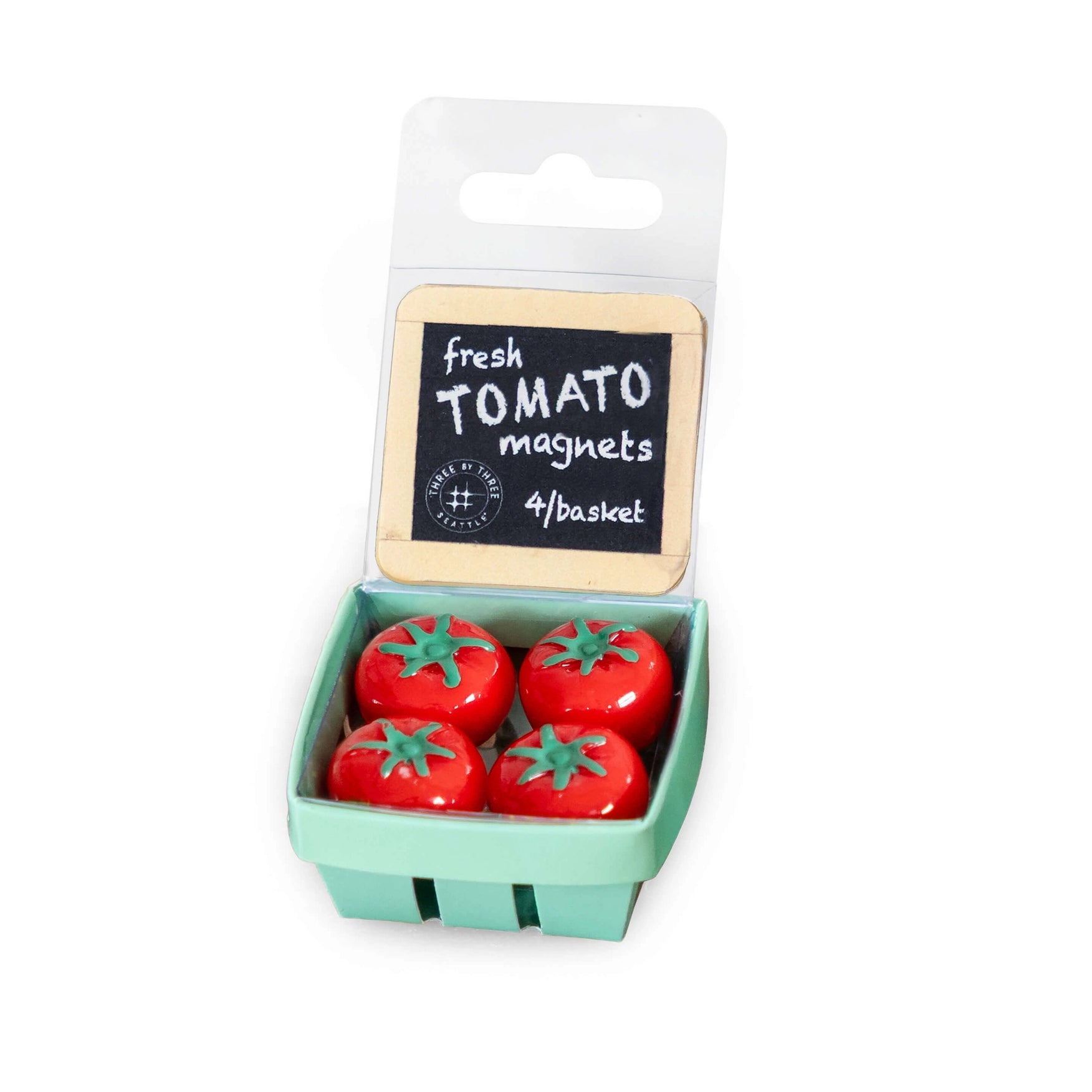 Four red tomato-shaped magnets in a mint green plastic basket package with a hanger card labeled 'fresh TOMATO magnets 4/basket' on a white background.