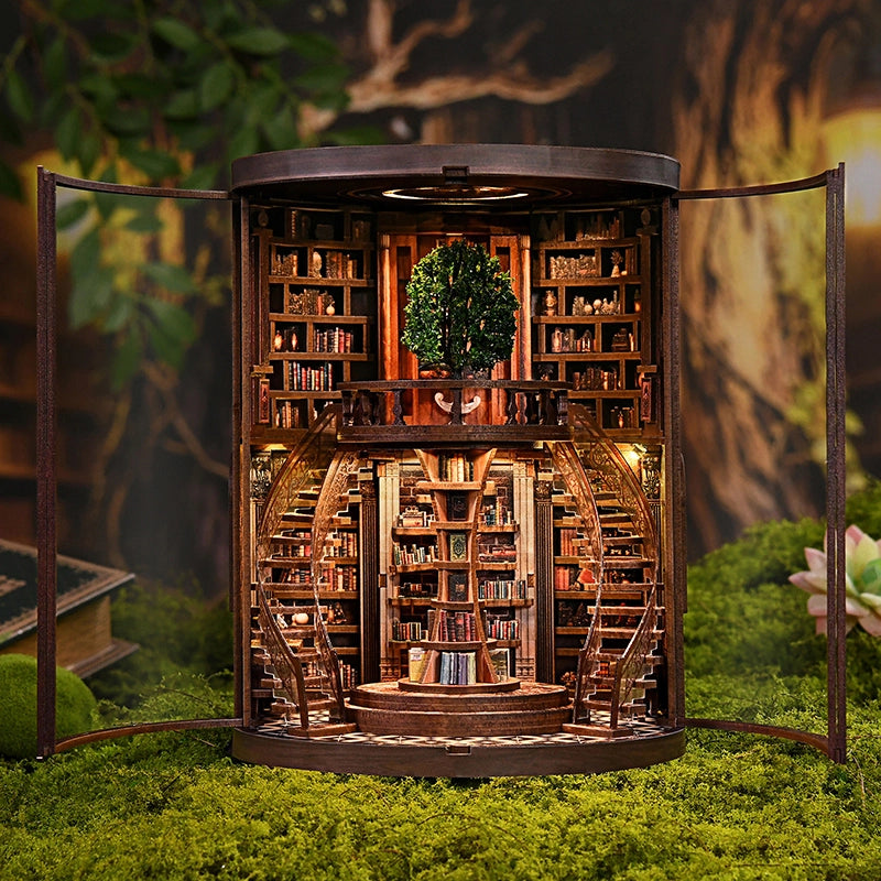 Miniature model of a library with bookshelves and a staircase, set against a natural background.