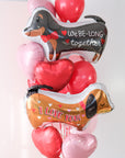 A closer photo of the the large balloon bouquet with two dog-shaped balloons that say "We Be-Long Together" and "I Love You" with heart balloons