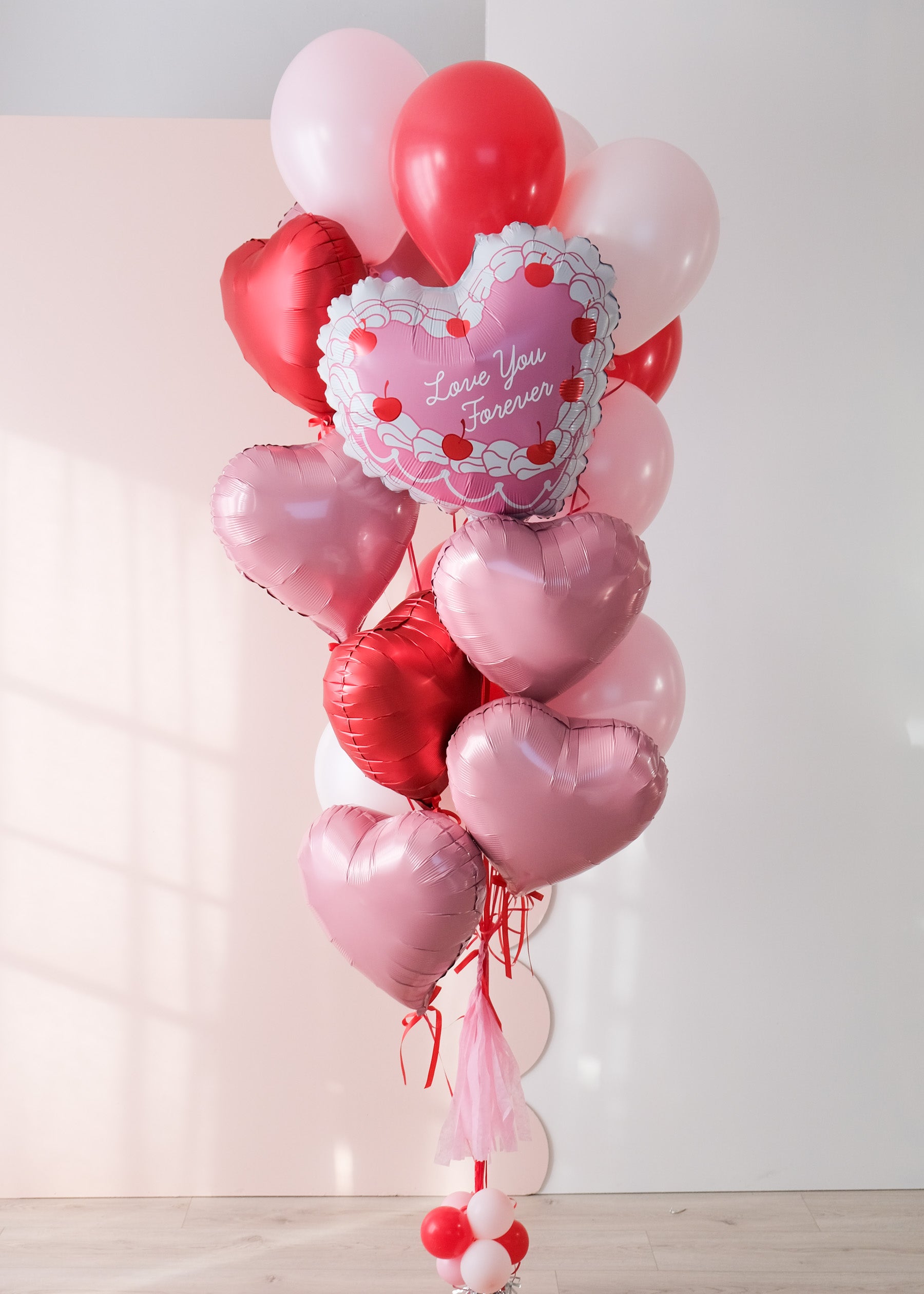 Red and pink large balloon bouquet featuring a vintage heart shaped cake