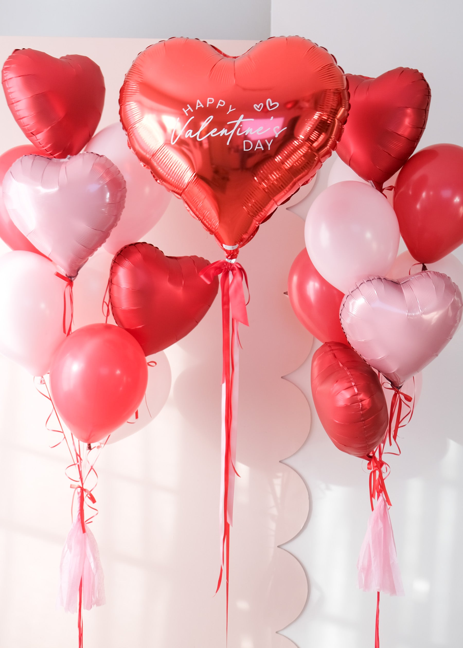 A closer look at the heart-shaped balloon bouquets with a 'Happy Valentine's Day' red heart balloon on a light background