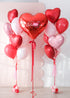 Heart-shaped balloon bouquets with a 'Happy Valentine's Day' red heart balloon on a light background