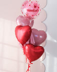 Clear bubble balloon with playful hearts with 5 heart balloons underneath