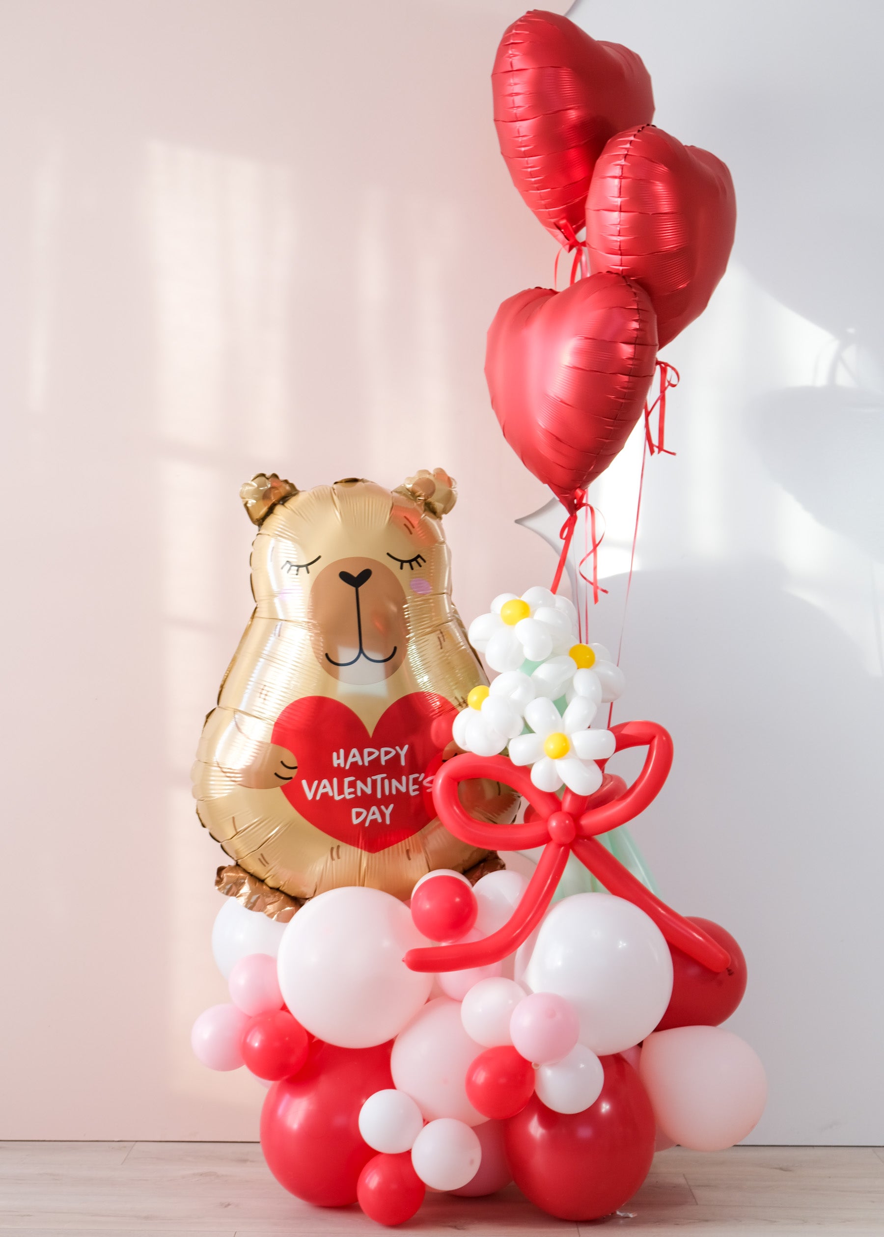 balloon cloud on the floor with capybara valentine's day balloon and daisy balloons