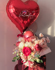 a person holding a bouquet of flowers and balloons with a large red heart balloon
