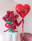 a person holding an 8-stem twisted rose balloon bouquet with red heart balloon