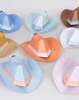 Colorful paper cowboy hats with decorative bands on a light background