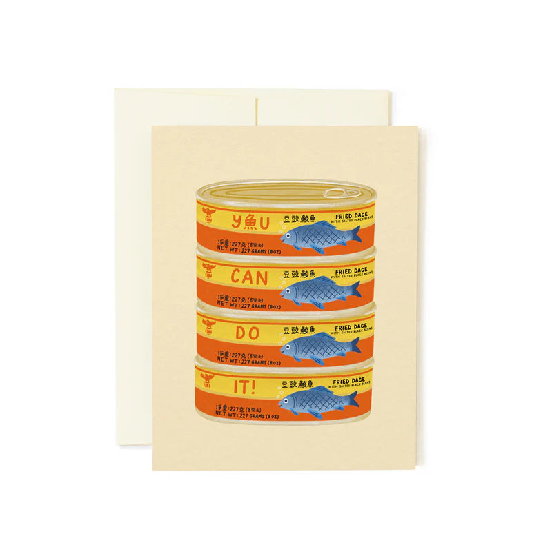 A greeting card with a graphic of a canned food item labeled 'YOU CAN DO IT', with a pun about fish and rice. The card also includes a matching envelope.