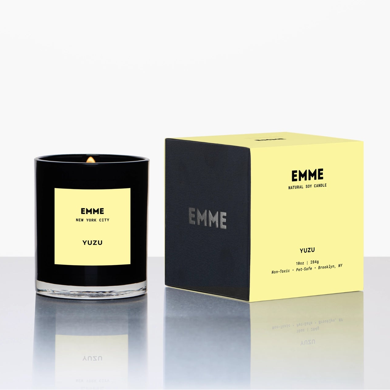 yuzu candle with black glass and packaging on white background