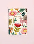 A colorful pocket notebook with a floral and animal kingdom theme on the cover.
