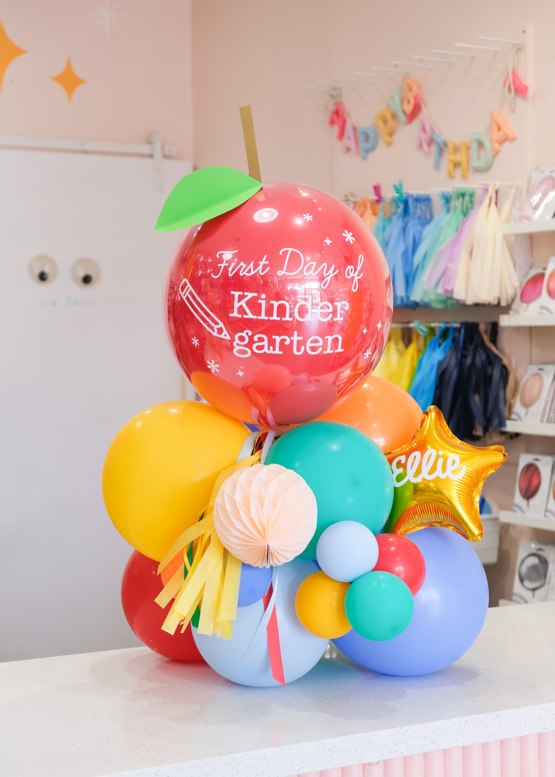 a tabletop balloon gift featuring a glossy apple shaped balloon that says "first day of kindergarten"