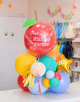 a tabletop balloon gift featuring a glossy apple shaped balloon that says "first day of kindergarten"