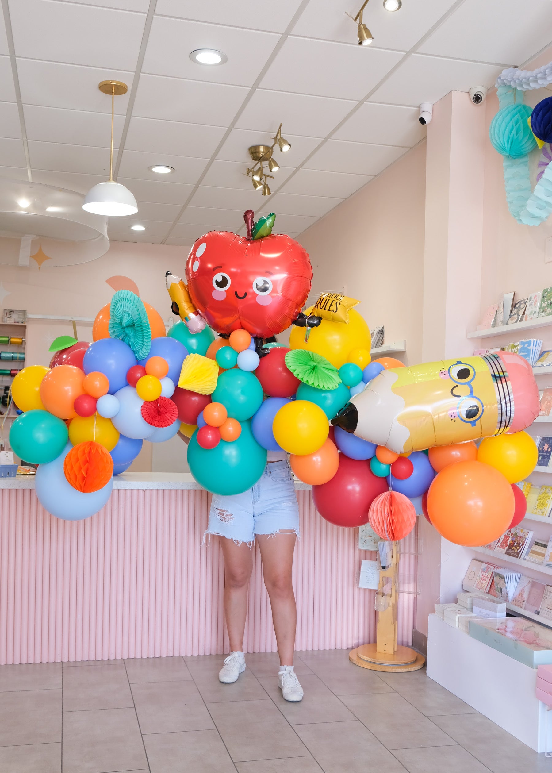 a 7ft balloon garland with in colorful shades with back to school shapes and honeycomb add-ins