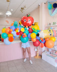 person holding a 7ft wide balloon garland with back to school themed shapes