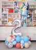 A balloon arrangement featuring a large number 2 balloon, a cloud-shaped balloon, and various other balloons with paw-print patterns and the name 'Chloe' printed on one of the balloons.