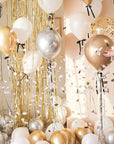 Cream round balloon popped with confetti floating around. Floating balloon with black ribbon bows surrounding.