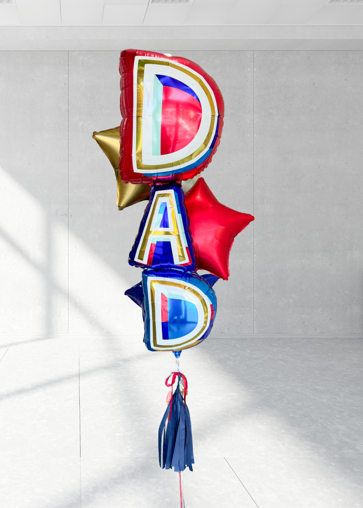 A bundle of Father's Day balloons with the word 'DAD' prominently displayed, featuring three stars behind it