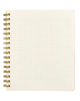 A square spiral-bound notebook with a cream-colored page featuring a grid of tiny green dots, bound with a gold-tone metal coil on a plain white background.