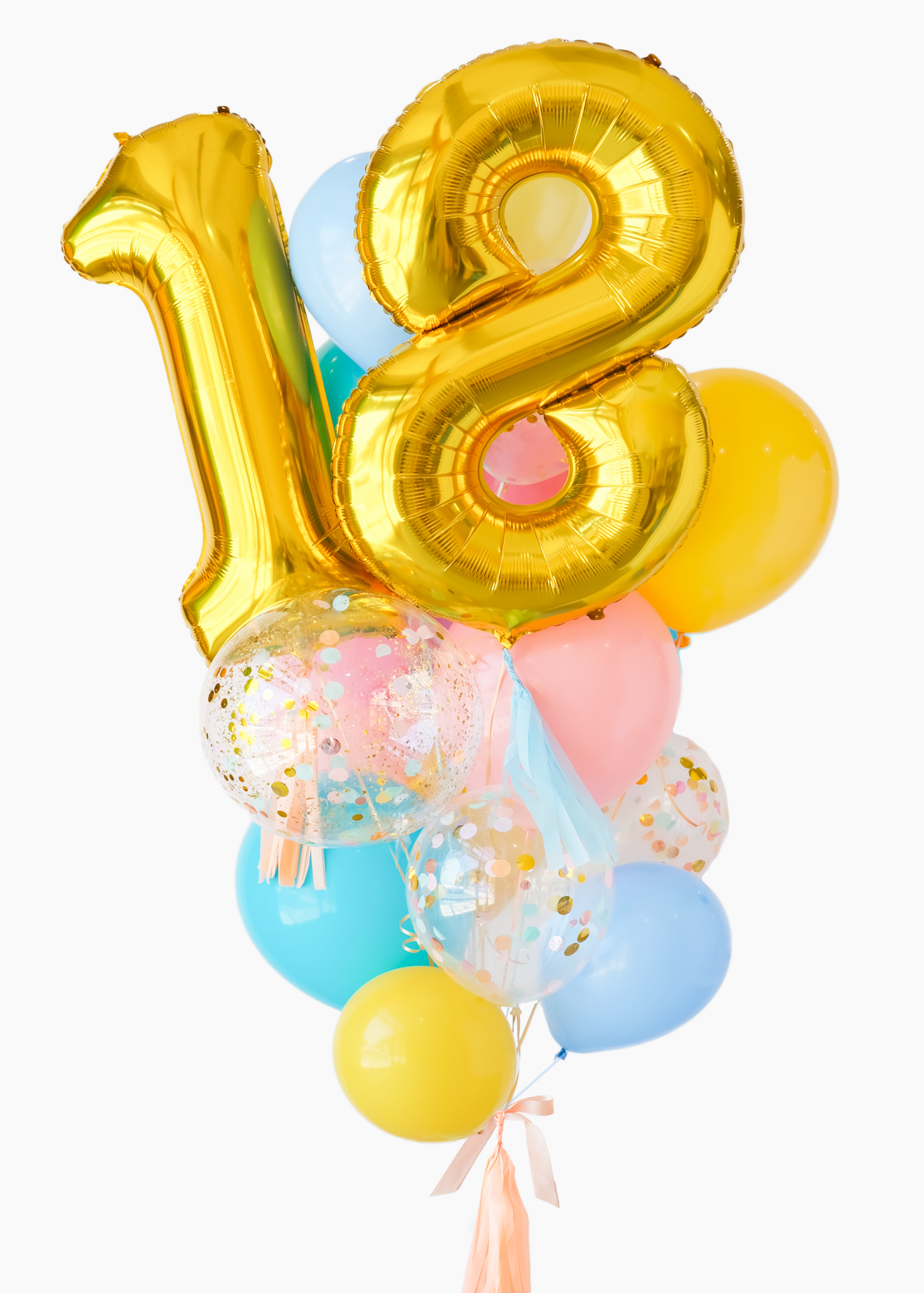 A balloon bouquet featuring a large gold number 18 balloon, with smaller multicolored balloons including pink, blue, and yellow, all adorned with confetti patterns. The balloons are attached to a ribbon bow and tassel.