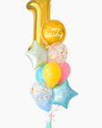 A balloon bouquet featuring a round gold orb balloon, a big gold number 1 balloon, with smaller multicolored balloons including pink, blue, and yellow, all adorned with confetti clear balloons and stars. The balloons are attached to a ribbon bow and tassel.