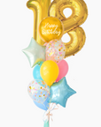 A balloon bouquet featuring a round gold orb balloon, gold number 18 number balloons, with smaller multicolored balloons including pink, blue, and yellow, all adorned with confetti clear balloons and stars. The balloons are attached to a ribbon bow and tassel.