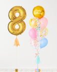 A balloon arrangement featuring a gold-colored number '8' balloon, along with rainbow balloons, tied together with ribbons.