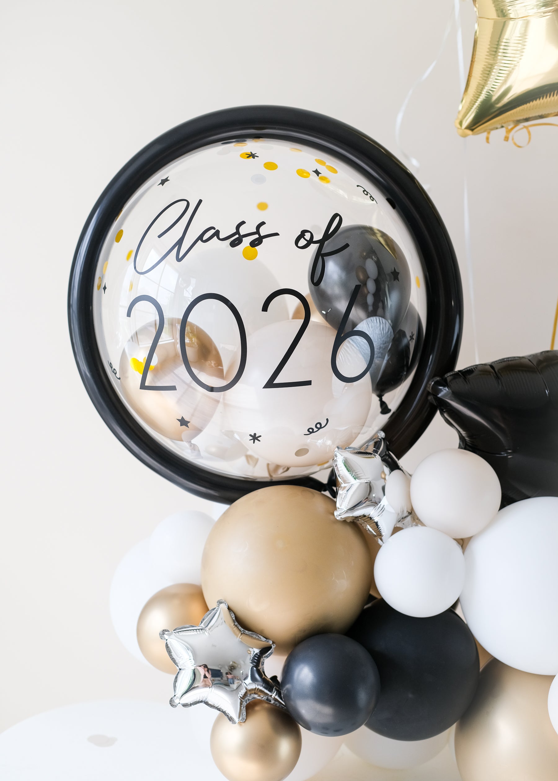 close up of clear balloon with mini balloons inside, featuring"Class of 2026" decal