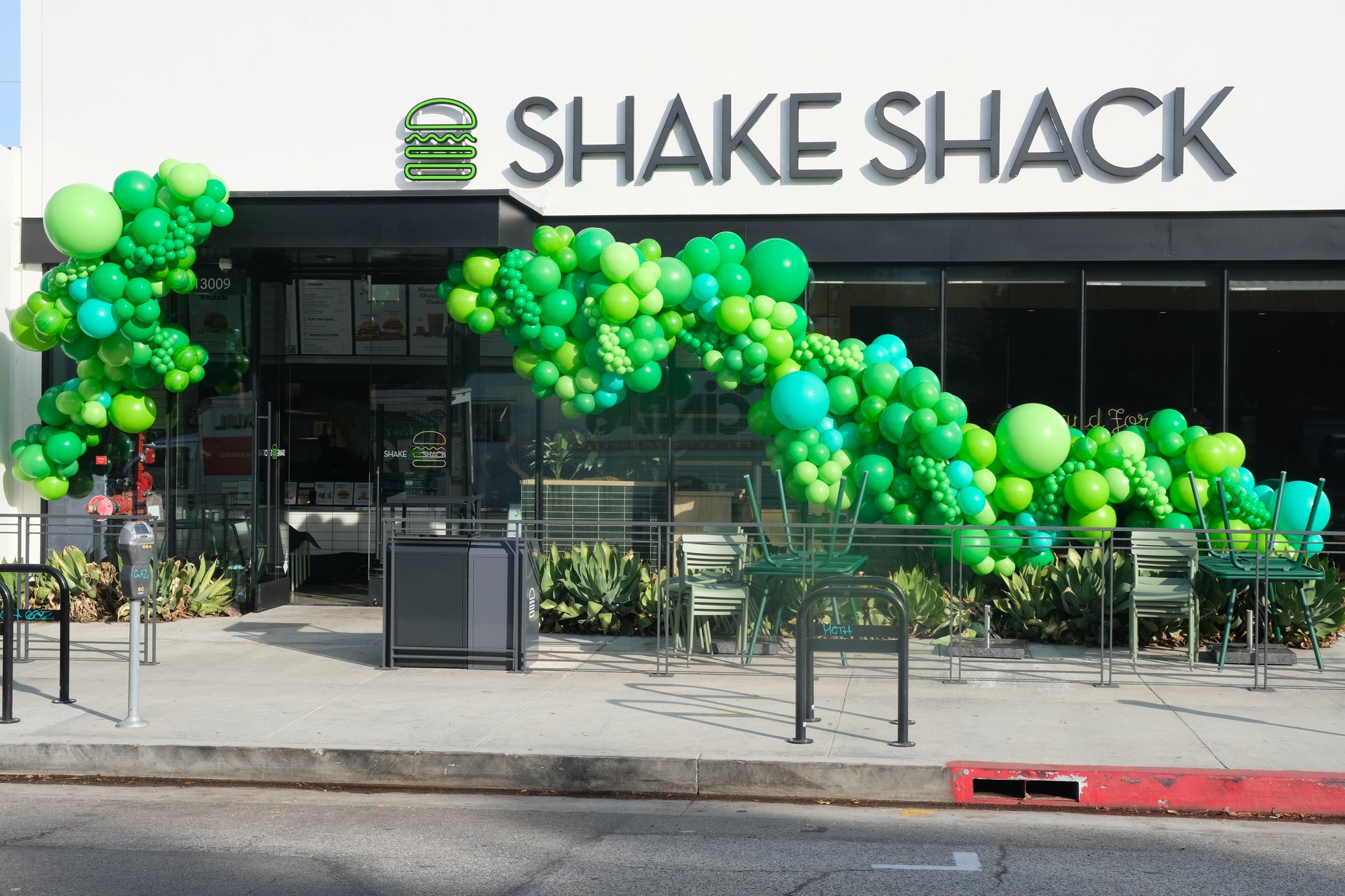 Shake Shack restaurant with green balloons arching over the entrance