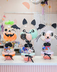 Halloween-themed balloons with cute face designs on a table.