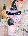 Decorative balloons shaped like a witch's hat and stars in a store setting.