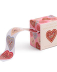 Box of heart-shaped envelope seals with a ribbon on a white background