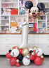 A large balloon cloud featuring Mickey Mouse shapes with classic Mickey colors, metallic stars, and a personalized name on a number balloon.
