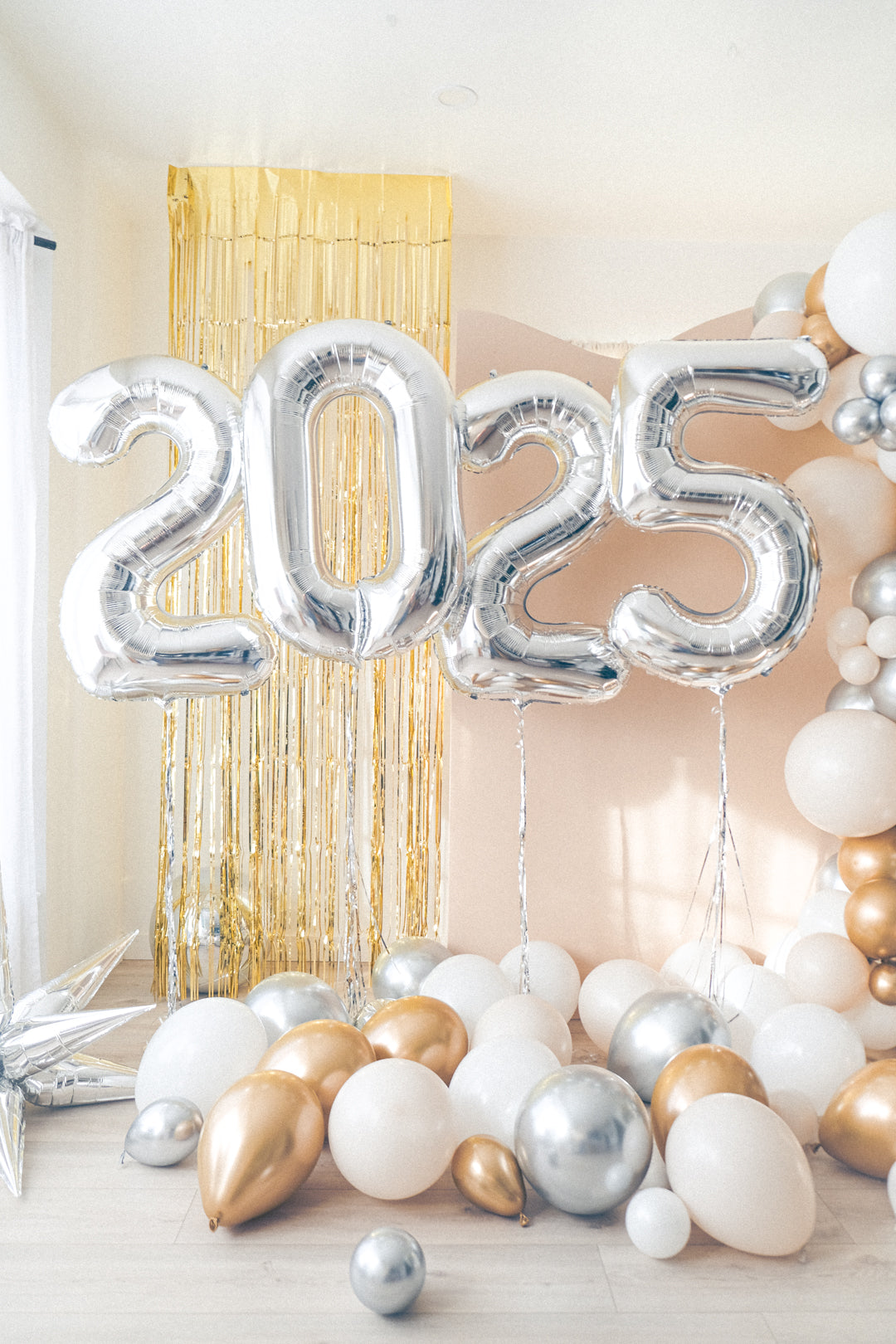 silver 2025 number balloons with cream, gold and silver balloons on the floor