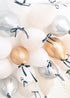 gold, silver and cream latex balloons with a black bow floating on the ceiling