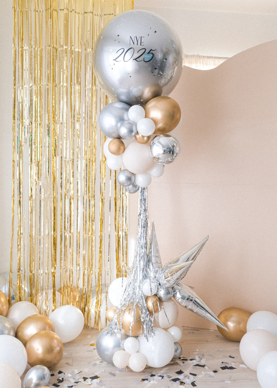 nye 2025 balloon tower with a giant round silver balloon and clusters of gold, silver and cream balloons underneath on a stand