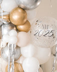 A close up shot of the balloon galrand in shiny silver, gold, white and creams with metallic tinsel and spikey balloon accents against a cream backdrop 