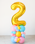 A rainbow number balloon stack with a gold 2 sitting on top and the option to add name decal in white on the top of the number.
