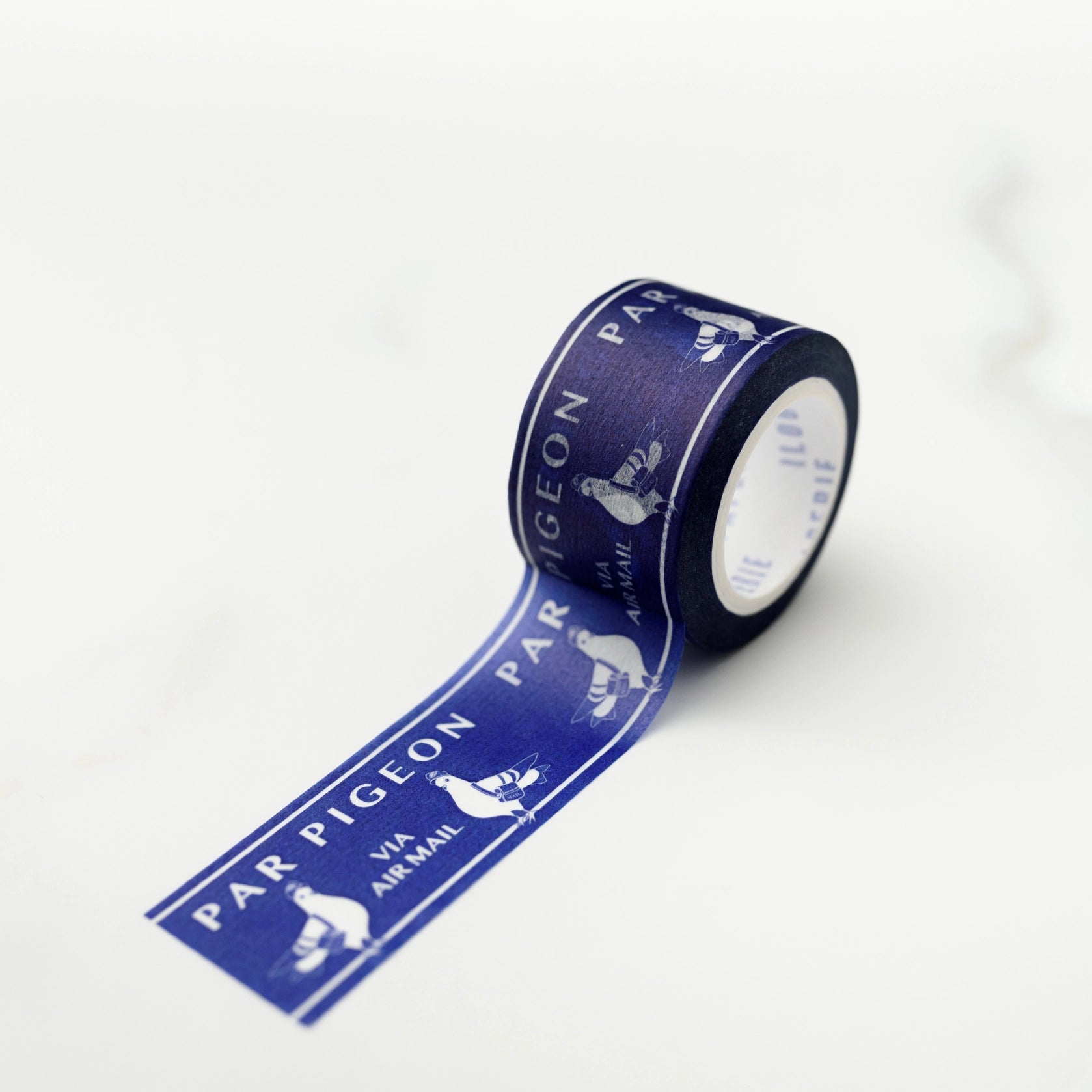 A roll of blue washi tape with white text and pigeon illustrations, partially unrolled to show the design.