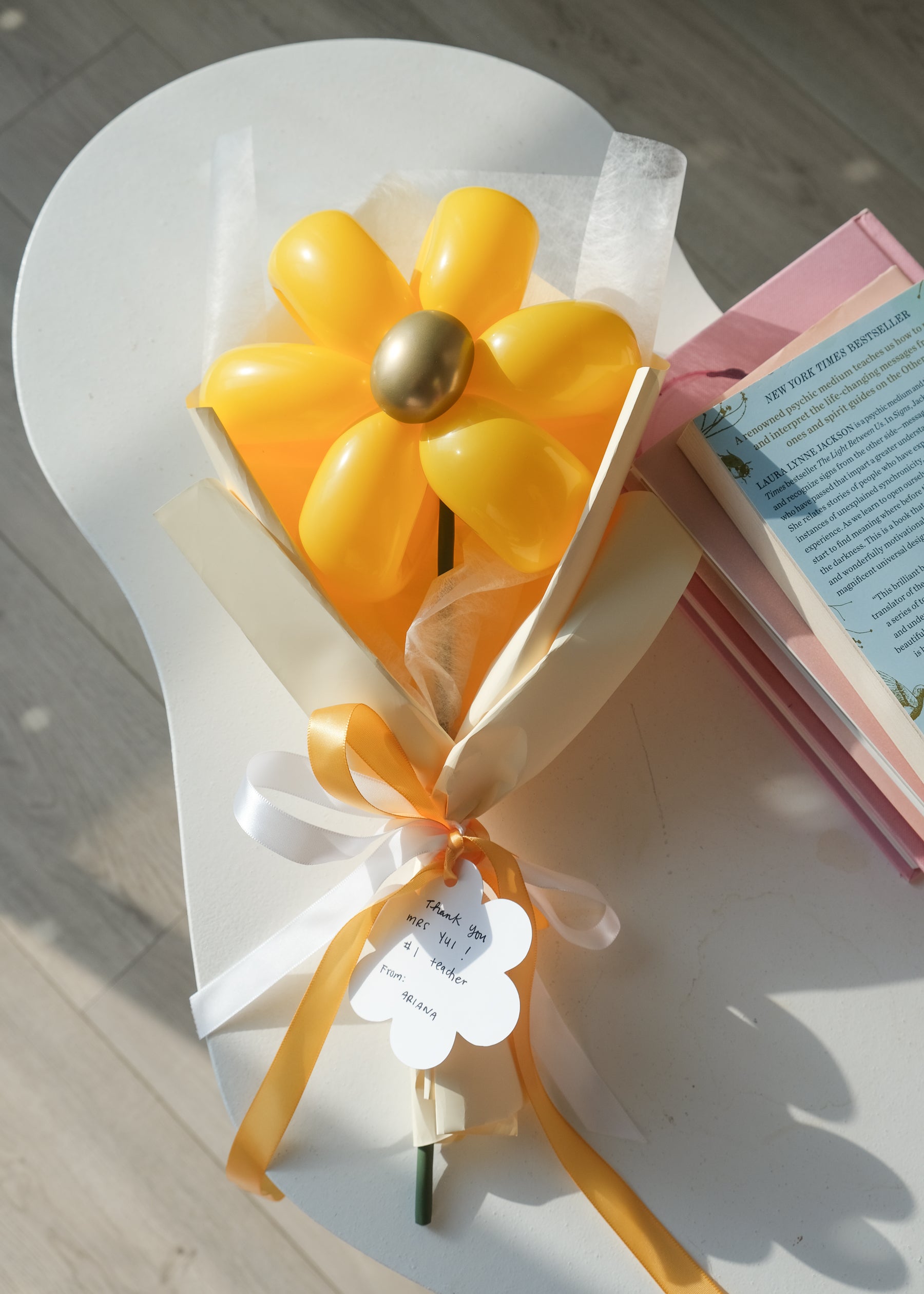 goldenrod balloon daisy on a coffee table with books