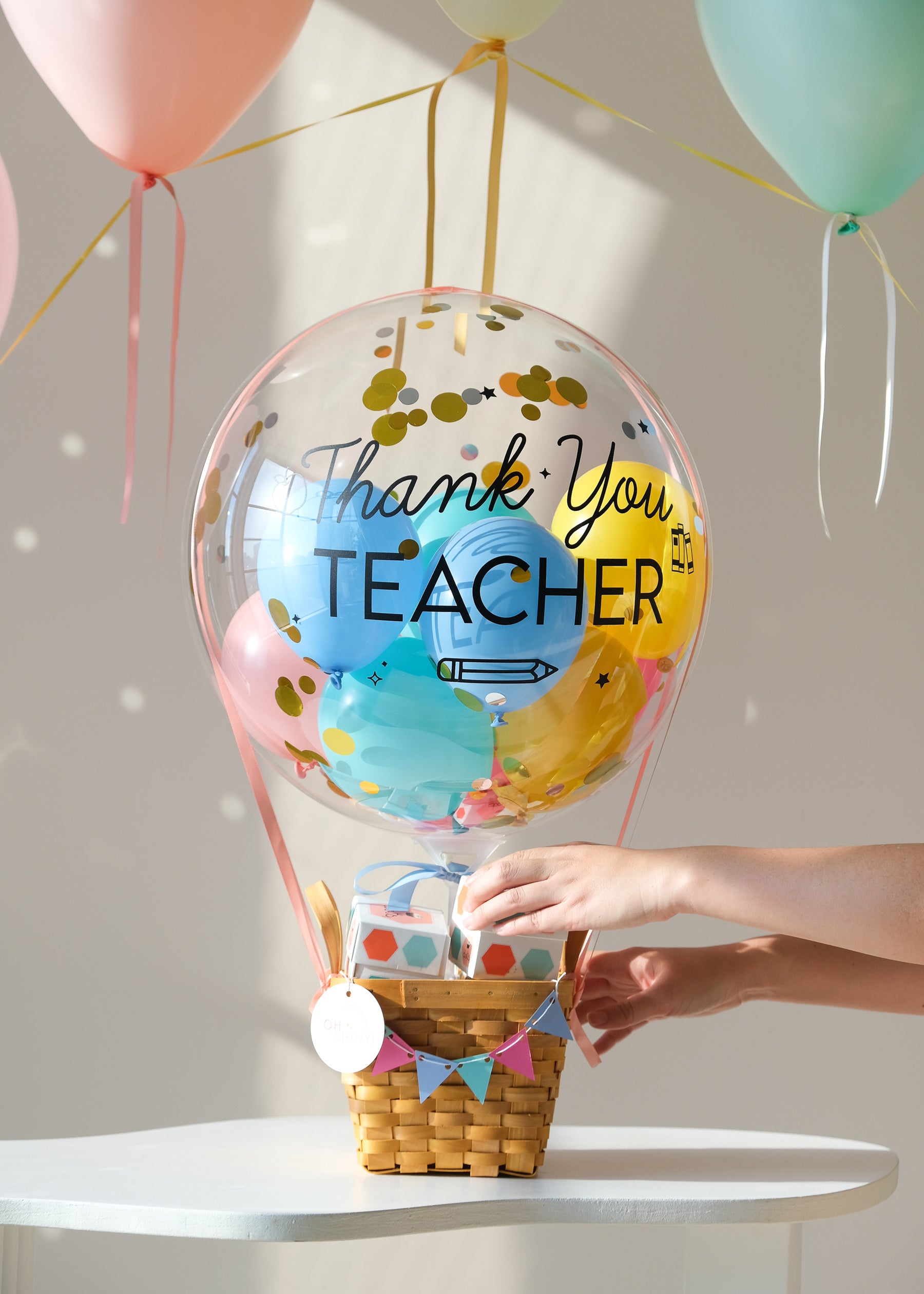 balloon gift shaped as a hot air balloon featuring a "thank you teacher" greeting with a hand reaching for a cupcake from the basket