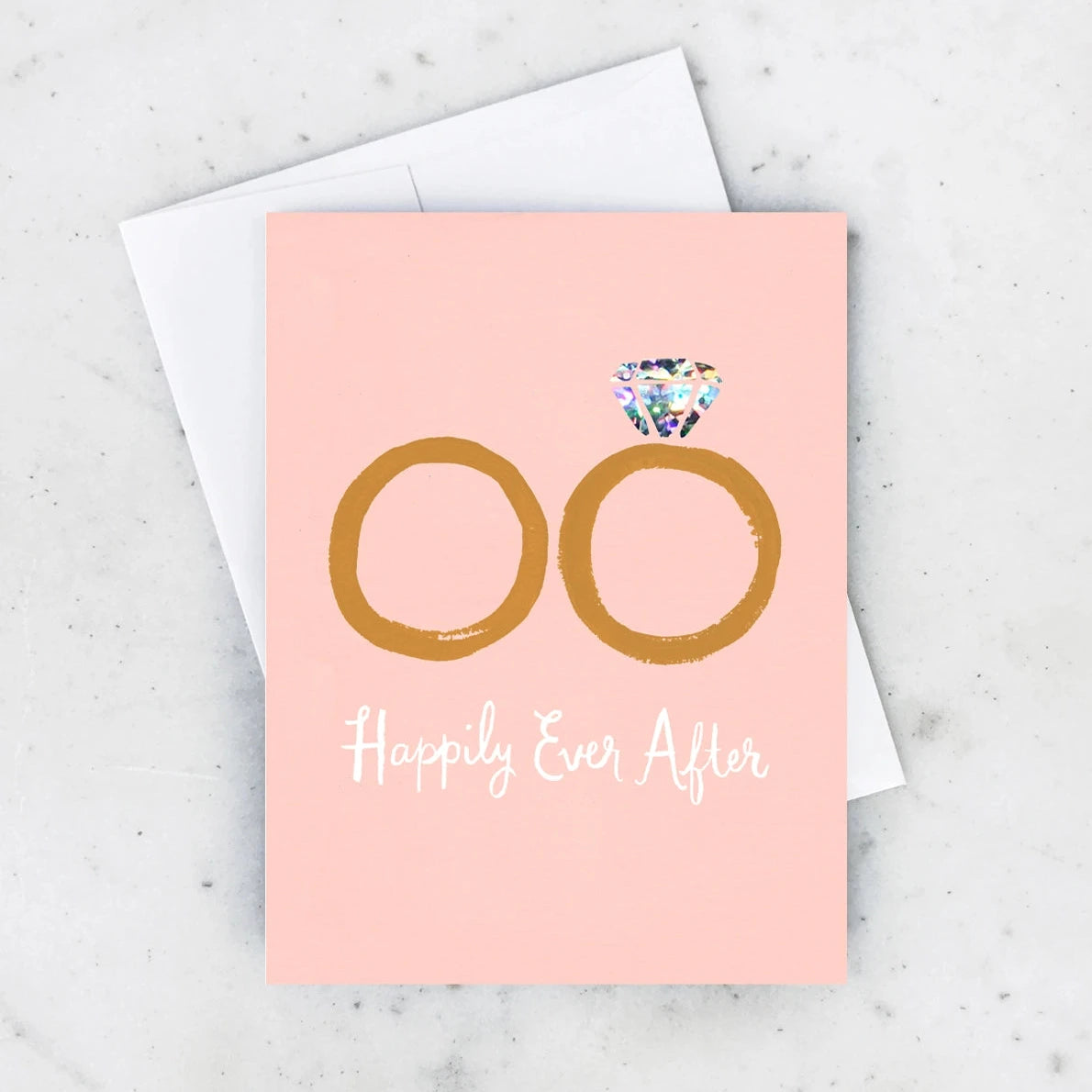 A pink greeting card with a holographic diamond and the text 'HAPPILY EVER AFTER' on it, accompanied by an envelope.