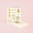 A greeting card with 'Welcome Baby' text and various pastel-colored illustrations of baby-related items such as a duck, a rattle, and a pair of baby shoes.
