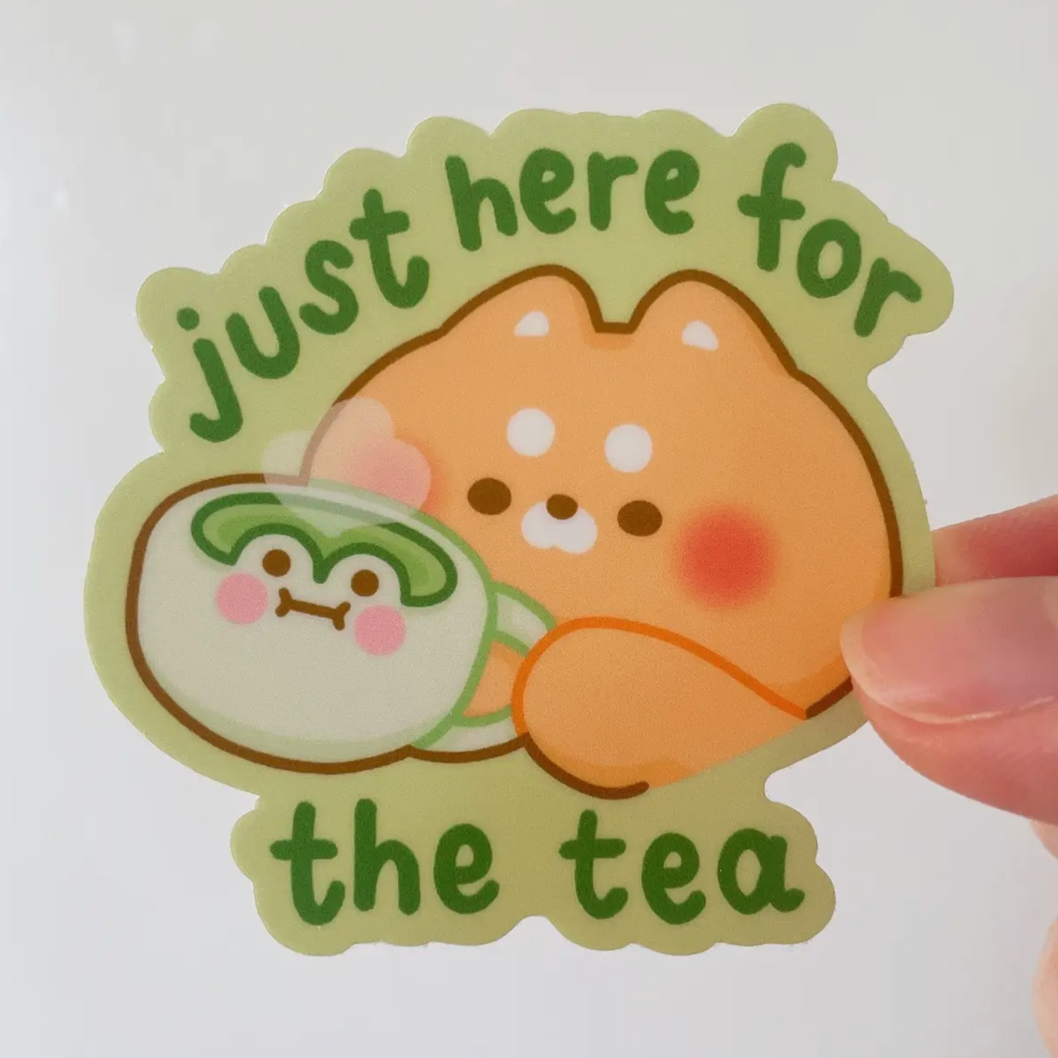 vinyl sticker with a bear holding a cup of matcha and text "just here for the tea"