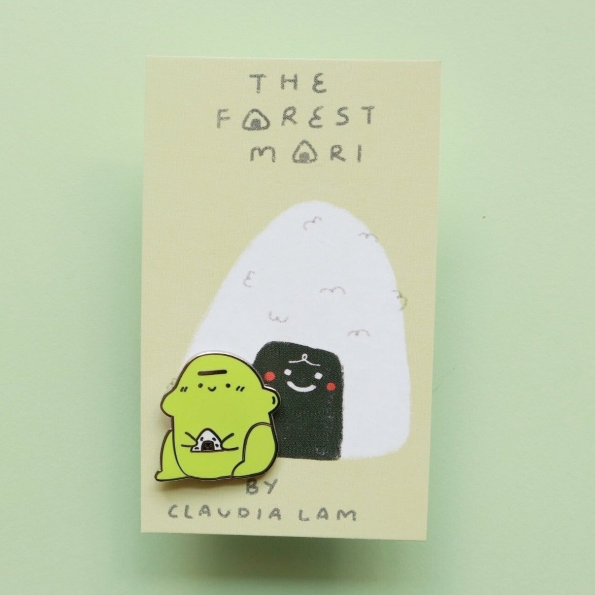 blob frog enamel pin holding rice ball